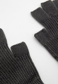 Tummanharmaat neulotut sormettomat hanskat, joissa on ribbitekstuuri ja avoimet sormenpäät. Ne esittelevät yksinkertaista muotoilua ja pehmeää materiaalia.