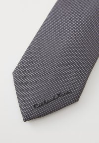 Cravate texturée gris foncé avec un motif subtil. Présente une extrémité pointue et inclut des coutures noires avec une signature de marque.