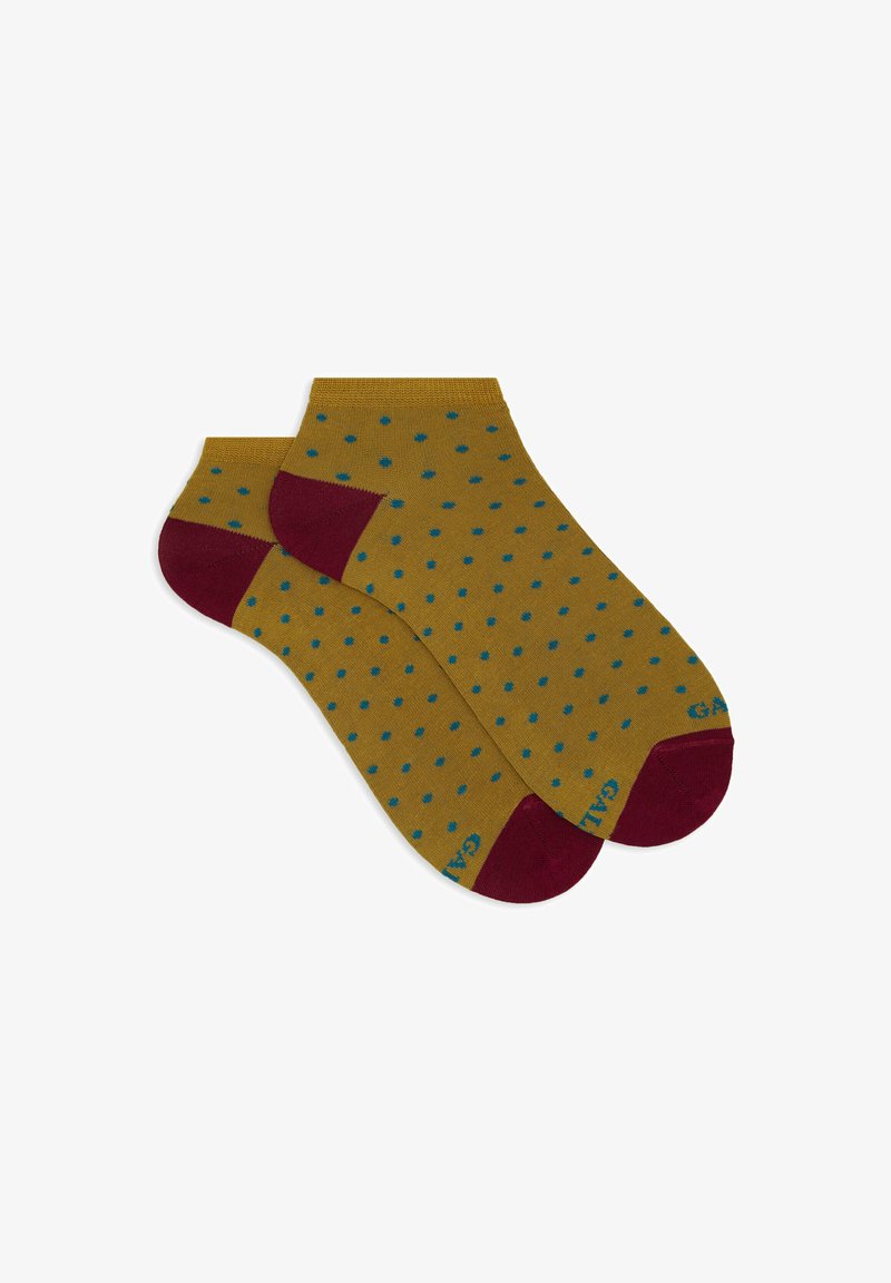 Knöchelhoche Socken in senfgelb mit türkisfarbenen Punkten und burgunderfarbenen Akzenten an Ferse und Zehen. Das Material scheint glatt und dehnbar zu sein.