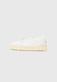 Sneaker bianco con tomaia in pelle strutturata, dettagli beige, punta rotonda e suola in gomma spessa e strutturata. Presenta sei fori per i lacci.