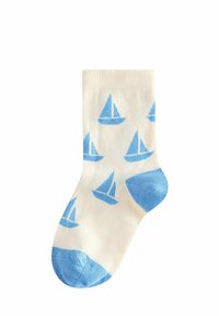 Bomullssockor i krämfärg med mönster av segelbåtar i blått. Har en blå tå och häl, ribbad mudd och en mjuk textur.