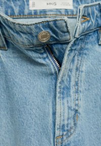 Jeans din denim de un albastru deschis, cu fermoar, închidere cu buton și detalii de cusătură vizibile. Materialul prezintă o textură uzată și o ușoară decolorare.