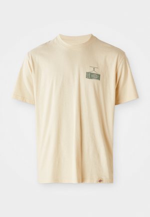 Tricou din bumbac de culoare crem, cu guler rotund, mâneci scurte și un imprimeu grafic pe partea stângă a pieptului, care ilustrează un televizor vintage.