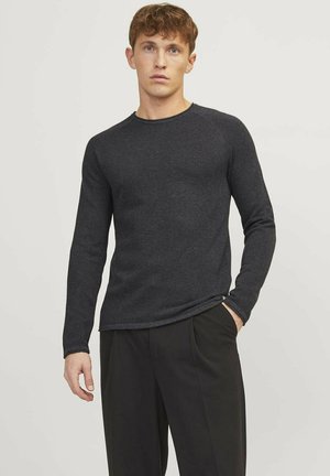 Camisa de manga larga gris oscuro hecha de material texturizado, con un cuello redondo y diseño ajustado, combinada con pantalones negros.