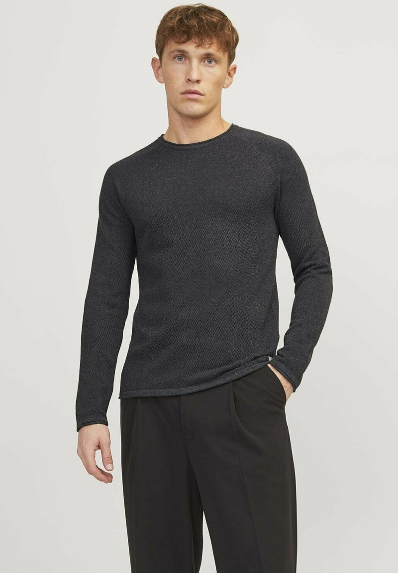 Camisa de manga larga gris oscuro hecha de material texturizado, con un cuello redondo y diseño ajustado, combinada con pantalones negros.