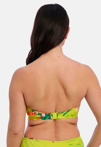 Geel bloemen bikini top met een klittenbandsluiting; bevat levendige groene bladeren en oranje-roze bloemen; gladde stoffen textuur.