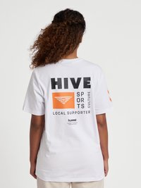 Vit bomullst-shirt med ett grafiskt tryck på baksidan med svart och orange text samt en triangulär logotyp. Kortärmad och lös passform.