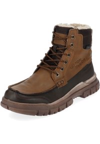 Brown leather high-top boot featuring a soft fur lining, thick rubber sole, and contrasting dark accents with brown laces and vents.
