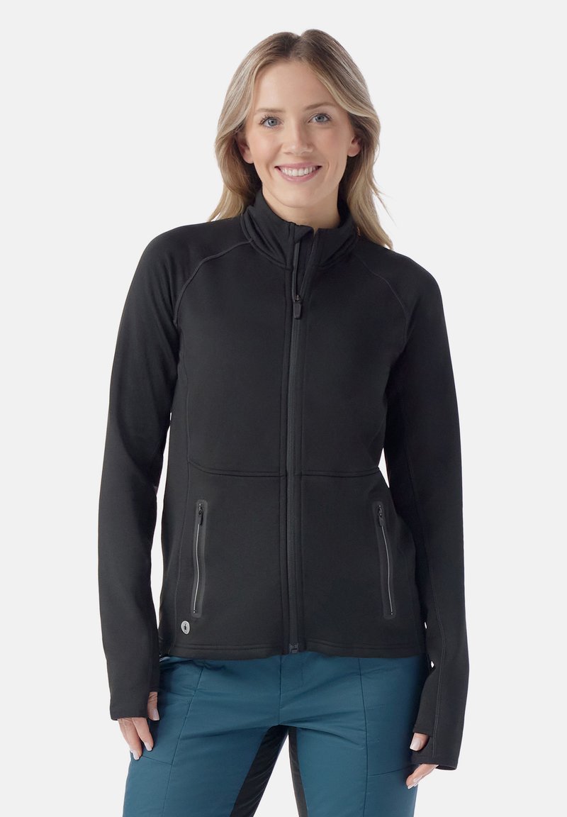 Giacca in pile nera con zip, caratterizzata da maniche lunghe, due tasche laterali con zip e un collo alto con cuciture raglan per una migliore libertà di movimento.