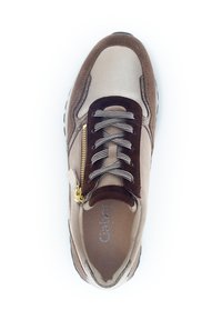 Beige en bruine suède sneaker met een textuuroppervlak, voorzien van vetersluiting, zijrits en contrasterende zwarte zool.