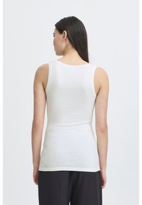 Valkoinen ilman hihoja oleva tank top, joka on valmistettu sileästä ja joustavasta kankaasta, slim fit -mallilla, pyöreällä kaula-aukkolla ja siistillä helmalla.