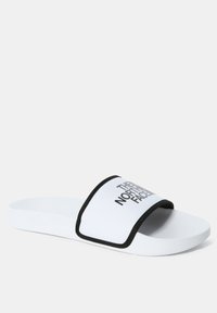 Hvit sandaler med bred stropp som har svart kant, med logoen "THE NORTH FACE" i fet svart tekst, teksturert gummisåle.