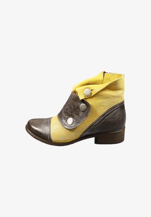 Stivale alla caviglia in pelle marrone con accenti perforati gialli, caratterizzato da grandi bottoni argentati e un design con risvolto. Tacco basso impilato.