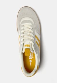 Weiße Sneaker mit gelben Akzenten, perforiertem Leder und strukturiertem Stoff. Ausgestattet mit flachen Schnürsenkeln, Branding auf der Zunge und einer gepolsterten Innensohle.