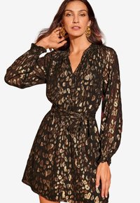 Rochie neagră cu imprimeu leopard auriu, cu mâneci lungi, închidere cu nasturi în față, manșete elastice și talie evidențiată printr-un brâu pentru un siluetă ajustată.