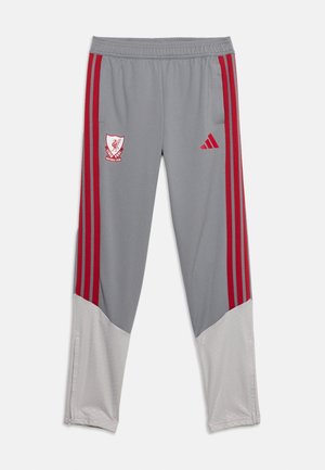 Pantalon de sport gris et blanc avec des bandes rouges sur les côtés, logo du club de football de Liverpool sur la cuisse gauche et logo Adidas rouge sur la cuisse droite.