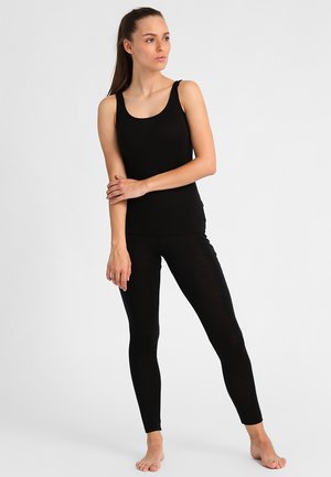 Ensemble débardeur noir et leggings en tissu doux et extensible. Le débardeur a un col rond, et les leggings présentent une coupe slim.