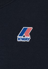 Donkerblauwe stof met een wit en gekleurd rubberen logo patch met een gestileerde "K" en drie rode diagonale lijnen boven "K-WAY."