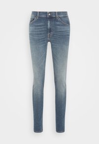 Slim fit jeans i ljusblå denim. Har en medelhög midja, femfickorsdesign och subtila blekning från mörk till ljus.