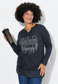 Zwarte langemouwenshirt met een getextureerde "WILD THING" grafiek in rhinestones. Heeft een ronde halslijn en zijknopen.