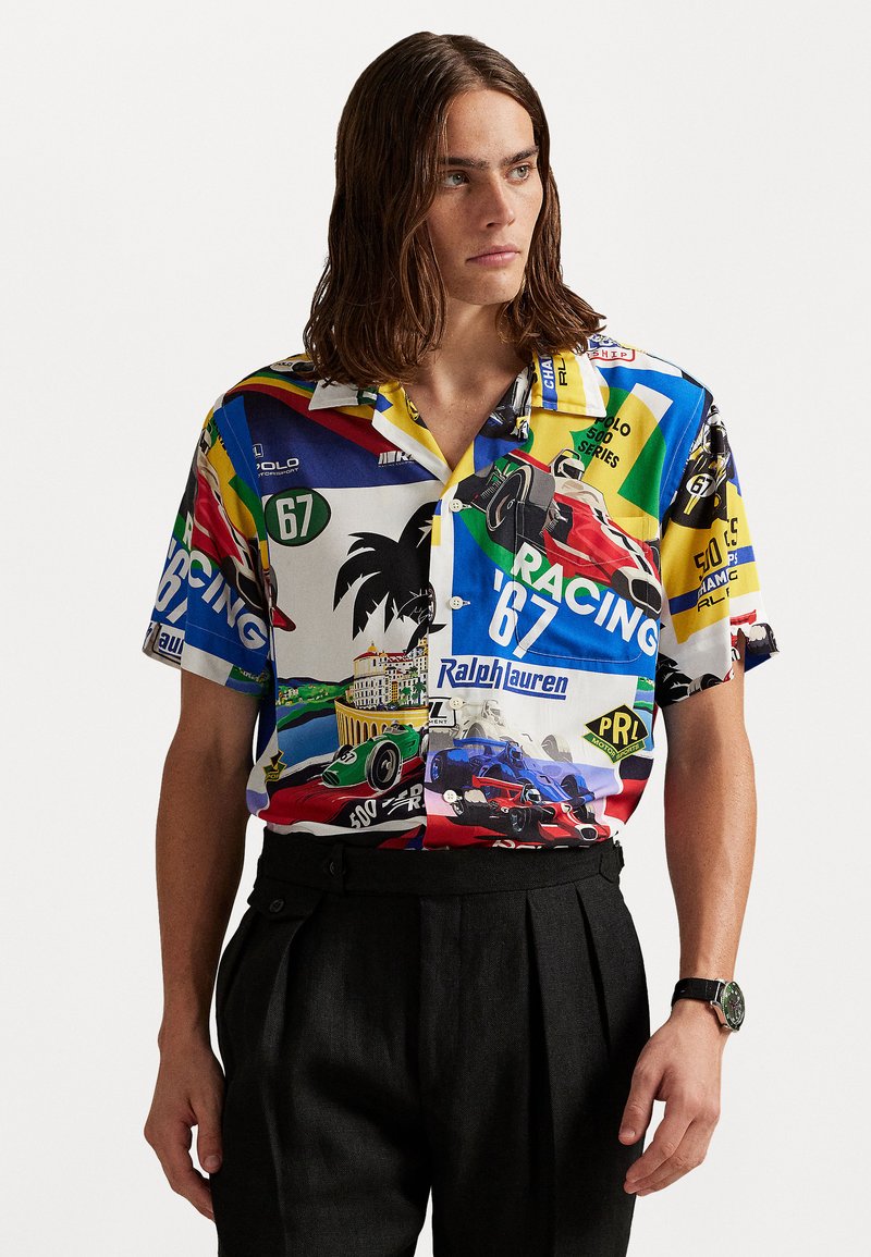 Camisa de manga corta con un estampado colorido de temática de carreras, confeccionada con un tejido ligero, con un corte relajado y un cuello con muesca.