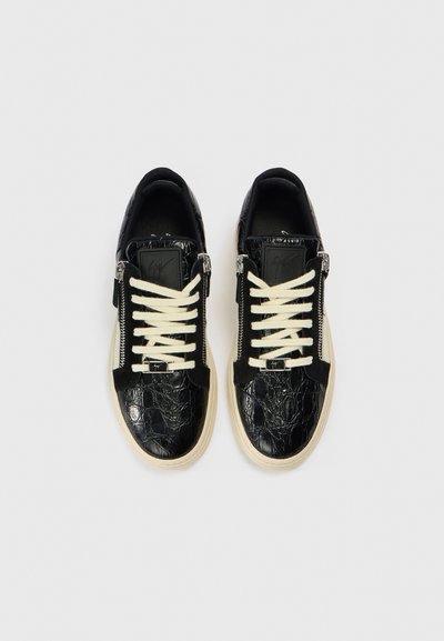 Μαύρα αθλητικά παπούτσια από υλικό με υφή μοτίβου κροκοδείλου, με εκρού κορδόνια και φερμουάρ. Διαθέτουν μαύρο λογότυπο στη γλώσσα.