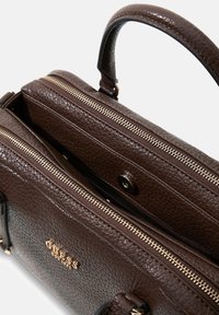 Dunkelbraune, strukturierte Lederhandtasche mit goldenen Reißverschlüssen, einem Tragegriff oben und einem goldenen Logo vorne, teilweise geöffnet gezeigt mit sichtbaren Fächern.