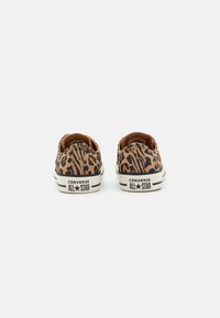 Leopardikuvioiset kangaskengät alhaalla olevaan muotoiluun ja valkoiseen kumipohjaan. Sisältää Converse All Star -brändin logo kantapäässä.