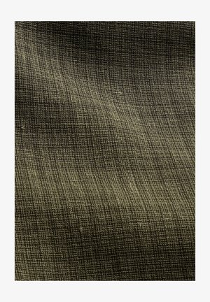 Gros plan sur un tissu tissé vert olive avec une texture en grille subtile et des variations naturelles de fil créant un motif légèrement en relief.