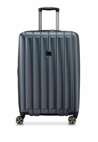 Valigia rigida con ruote in grigio scuro. Caratterizzata da scanalature verticali, manico retrattile e quattro ruote con dettagli cromati. Chiusura con zip.