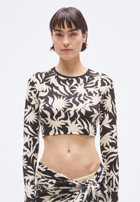 Κοντό τοπ με μακριά μανίκια, με μαύρο και κρεμ αφαίρετο λουλουδένιο μοτίβο, εφαρμοστό σχέδιο και υφή υφάσματος.