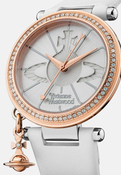 Wit leren horloge met een zilveren wijzerplaat met stralende lijnen, roségouden accenten en een bezel met sierstenen. Voorzien van een hangend bedeldetail.
