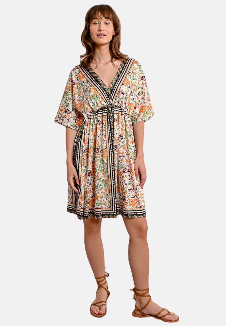 Abito floreale con scollo a V, maniche corte oversize e vita impero. Presenta bordi neri e una gonna fluida. Colorato con motivi intricati.