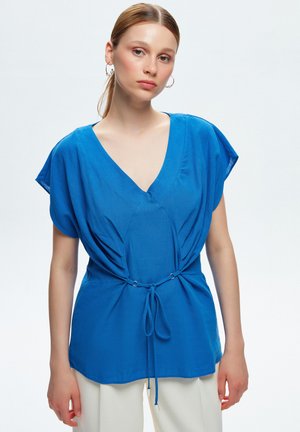 Blauwe blouse met een V-hals, korte mouwen, geplooide stof en een koorddetail in de taille. Gemaakt van lichtgewicht stof.