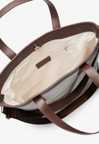 Brown leather tote bag with a smooth texture. Interior features a beige lining, zip pocket, and a snap closure. Dual handle design.