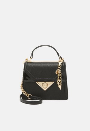 Sort tekstureret håndtaske med top håndtag, trekantet gyldent spænde, gylden kæderem og dekorative gyldne charms på en ensfarvet baggrund.