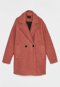 Cappotto rosa, strutturato, doppiopetto con ampio colletto, due tasche laterali e bottoni neri. Materiale morbido e soffice con un interno caldo.