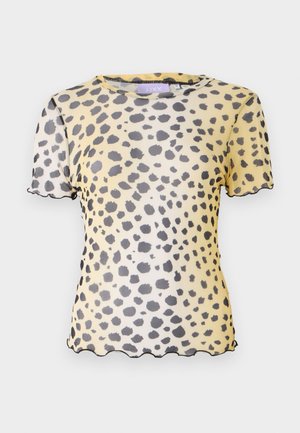 Kortermet, gul bluse med svart leopardmønster, gjennomsiktig materiale og bølgete kanter på ermene og nederkanten.