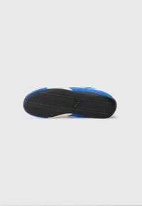 Blauwe sportieve schoen onderkant met rubberen buitenzool die is voorzien van een gestructureerd loopvlak en contrasterende crèmekleurige zijdetails. Over het algemeen een gladde afwerking.