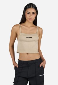 Beige ribbed crop top with adjustable spaghetti straps and a square neckline, featuring a black logo centered on the chest.