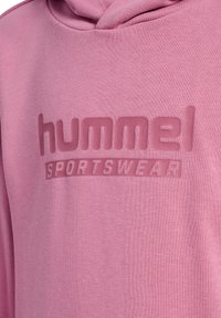 Rosa Kapuzenpullover mit weicher Textur und erhöhtem Logotext "hummel" und "SPORTSWEAR" auf der Vorderseite in einem passenden Farbton.