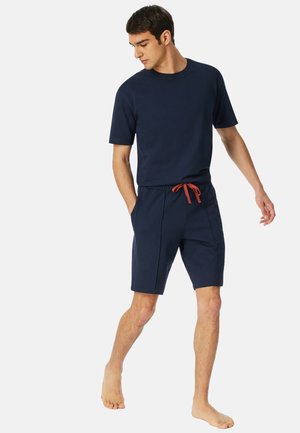 Marineblaues T-Shirt mit kurzen Ärmeln und passenden Shorts mit elastischem Bund und ropem Kordelzug. Weicher Stoff, lockere Passform und keine Muster.