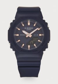 Orologio da polso G-SHOCK con cinturino in resina blu navy, quadrante rotondo, accenti in oro rosa, display digitale e resistenza all'acqua fino a 20 bar.
