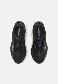 Svarta sportskor med nätöverdelar, reflexdetaljer och vita sulor har en strömlinjeformad design och platta skosnören för en säker passform.