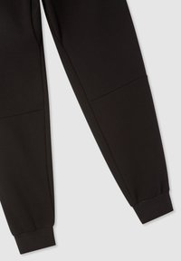 Pantaloni della tuta neri realizzati in morbido tessuto misto cotone, con gambe affusolate e polsini elastici alla caviglia per un look aderente.
