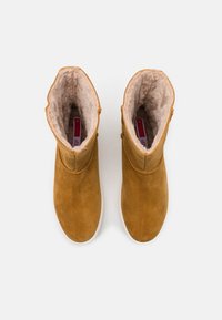 Bottes basses en daim couleur fauve chaud avec une doublure intérieure douce et moelleuse. Design discret avec un bout arrondi et une semelle en caoutchouc durable. Taille 37.