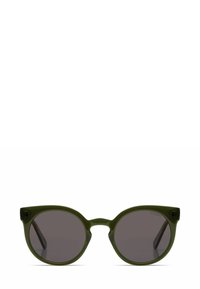 Occhiali da sole rotondi con una montatura in plastica verde oliva, lenti scure e una leggera forma a occhio di gatto con semplici dettagli neri sulle stanghette.