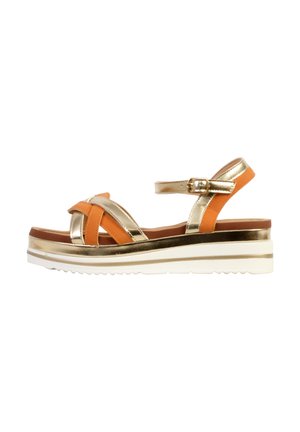 Wedge sandal with gold and orange leather straps, ankle buckle, and thick white platform sole with ridged bottom.