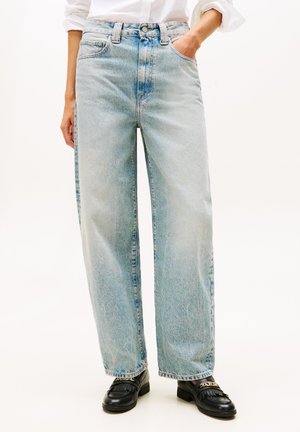 Light blue high-waisted jeans with a loose fit, featuring faded denim texture, side pockets, and a button closure. Paired with black shoes.