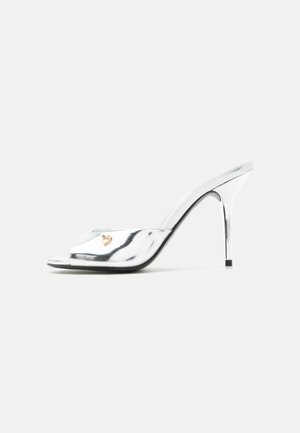 Silver high-heeled mule with open toe, slim stiletto heel, and small gold heart embellishment on the strap.